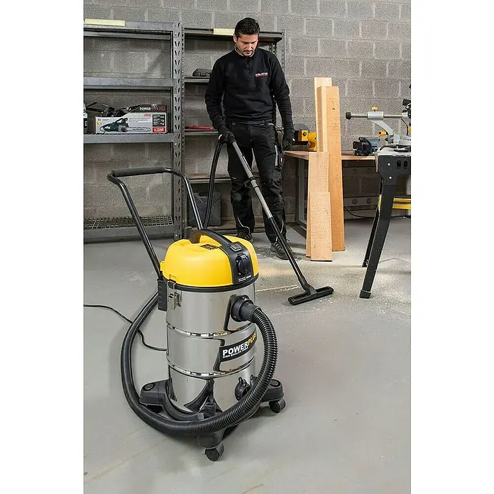 PowerPlus Aspirador en seco y húmedo eléctrico POWX3240 - 1.200 W, Volumen de recipiente: 30 l, Con bolsa - Aspiradora Powerplus en acción, utilizada por un operario para quitar serrín del taller.