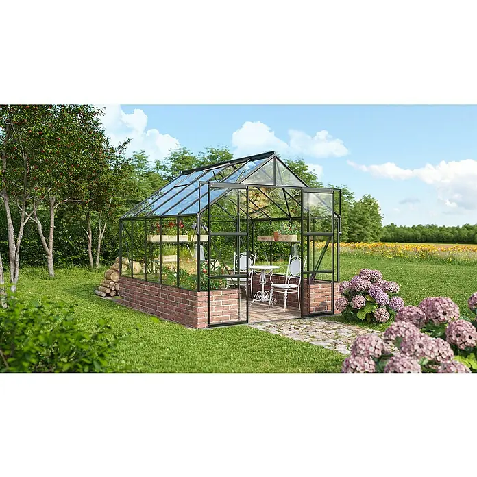 Vitavia Gewächshaus Cassandra 8300 - Außenmaß inkl. Dachüberstand (B x T): 257 x 323 cm, 3 mm, Schwarz - Das Bild zeigt ein Gewächshaus mit einem Tisch und Stühlen im Inneren, umgeben von Pflanzen und Blumen, die ein entspannendes Ambiente schaffen.