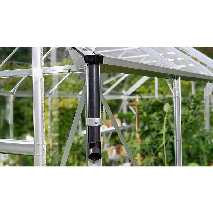 Vitavia Gewächshaus Cassandra 11500 Plus - Außenmaß inkl. Dachüberstand (B x T): 257 x 448 cm, 3 mm, Aluminium - Nahaufnahme eines schwarzen Regenrinnenrohrs an einem Gewächshaus mit silberfarbenem Rahmen und viel Grün im Hintergrund.