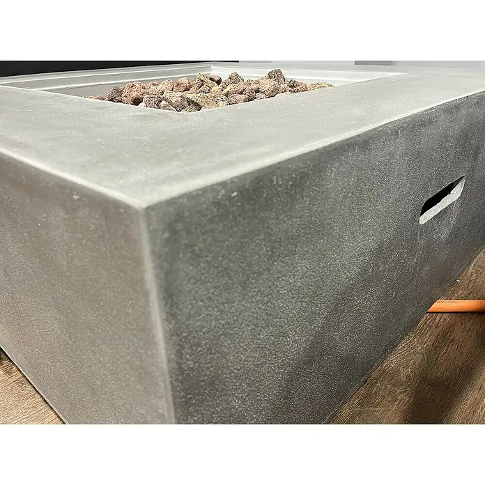 Nora Flames Brasero de gas Loa - 16 kW, L x An x Al: 86 x 86 x 35 cm, Acero, Gris - Primer plano de un fogón cuadrado gris con rocas de lava, creando un ambiente exterior moderno y acogedor.