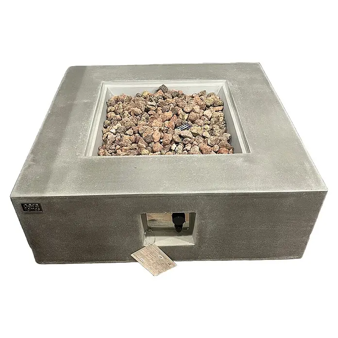 Nora Flames Brasero de gas Loa - 16 kW, L x An x Al: 86 x 86 x 35 cm, Acero, Gris - Esta foto muestra un moderno brasero Nora Flames, lleno de rocas decorativas, prometiendo un ambiente cálido y acogedor.