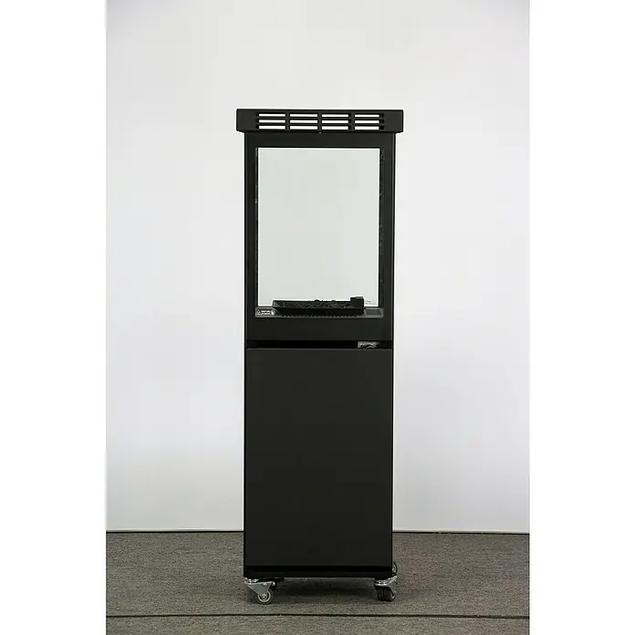 Nora Flames Estufa de exterior de gas Mavros - 8 kW, Altura: 128,5 cm, Negro - La imagen muestra una chimenea eléctrica negra y rectangular sobre ruedas con una inserción de vidrio transparente. La chimenea está frente a una pared blanca.