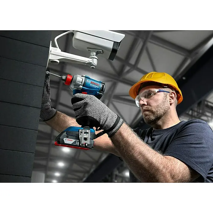 Bosch Professional AMPShare 18V Akku-Drehschlagschrauber GDX 18V-285 - 18 V, Ohne Akku, 285 Nm - Ein Handwerker befestigt mit einem blauen Bosch GDX 18V-200 Akku-Schlagschrauber eine Überwachungskamera an einer Wand.