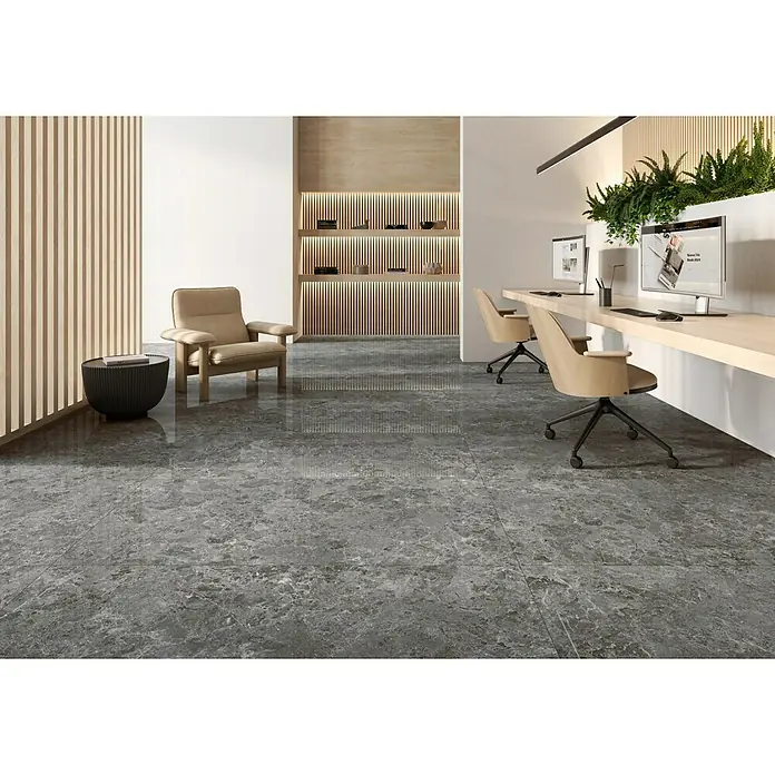 BHS Showroom Pavimento porcelánico Marais Slim - 80 x 160 cm, Grafito, Brillante, Rectificado - Interior de oficina con un suelo de baldosas gris oscuro, creando un ambiente elegante y moderno, complementado con mobiliario de oficina y plantas.