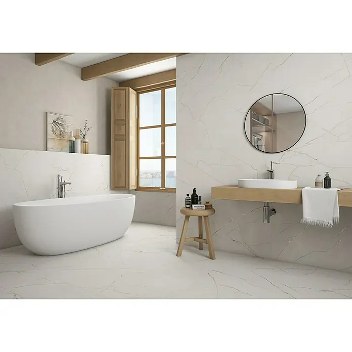 Pavimento porcelánico Lincon - 60 x 120 cm, Blanco, Mate, Rectificado - Baño con bañera exenta, espejo redondo y estante de madera. Los azulejos de mármol añaden un toque elegante al espacio.