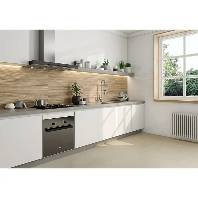 Revestimiento de pared Suite Chablis - 30 x 90,2 cm, Roble, Mate, Rectificado - Cocina moderna con armarios blancos, una encimera gris y un fregadero integrado. Destaca el horno oscuro de Bosch bajo la placa de cocción.
