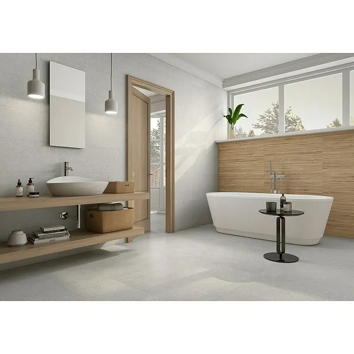 Revestimiento de pared Yafra - 30 x 90,2 cm, Gris, Mate, Rectificado - Un baño luminoso con azulejos blancos, una bañera exenta y un tocador de madera para un ambiente relajante.
