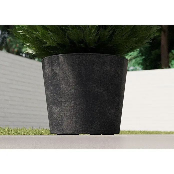 Deroma Millennium Pflanzkübel rund - Außenmaß (Ø x H): 59 x 49 cm, Aus recyceltem Kunststoff, Anthrazit - Nahaufnahme eines schwarzen Pflanzgefäßes mit einem grünen Busch darauf, vor einem neutralen Hintergrund platziert.