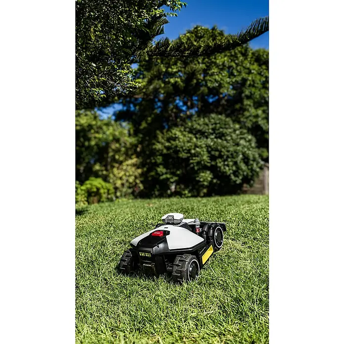 Mammotion Mähroboter Luba Mini AWD 800800 m², Schnittbreite: 200 mm, Satellitengestützte Navigation, RTK - Ein Rasenmähroboter auf einem grünen Rasen vor Bäumen und blauem Himmel.