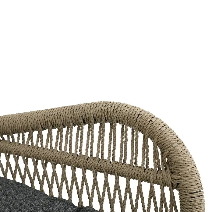 Conjunto de muebles Frida - 5 pzs., Acero/Textiline, Antracita/Marrón - Primer plano de una silla de ratán con un cojín gris. La textura tejida y la paleta de colores naturales se muestran de forma destacada.