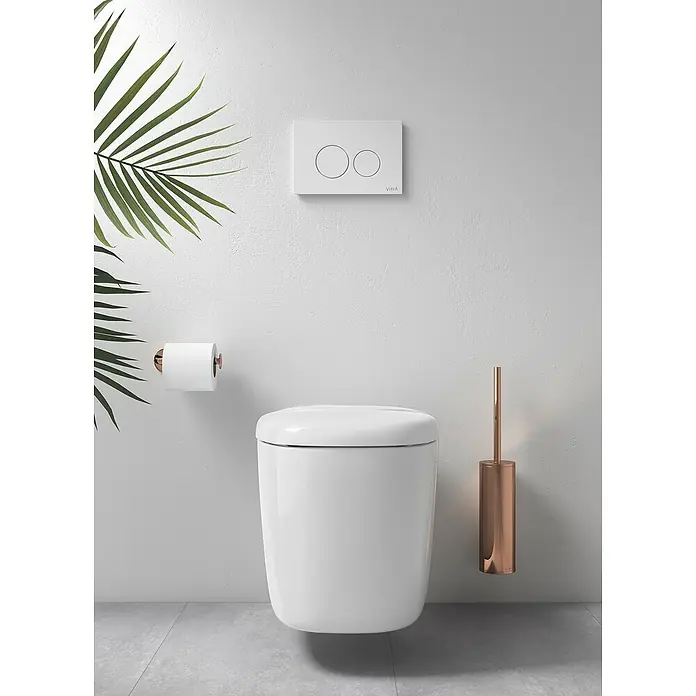 VitrA Plural WC-Sitz - Duroplast, Weiß, Mit Absenkautomatik - Das Bild zeigt eine moderne, wandhängende Toilette mit einer eleganten Spültaste und einem passenden Toilettenbürstenhalter in Kupferoptik.