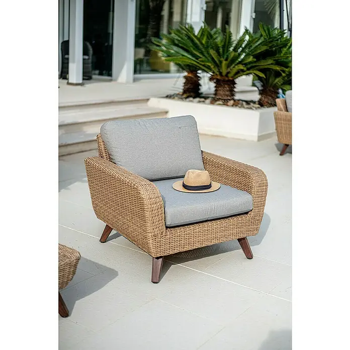 Sillón de jardín Royal Riviera - An x Pr x Al: 89 x 93 x 75 cm, Beige - Sillón de mimbre acogedor con cojín gris y sombrero de paja, perfecto para relajarse al aire libre. Diseño elegante para terraza o jardín.
