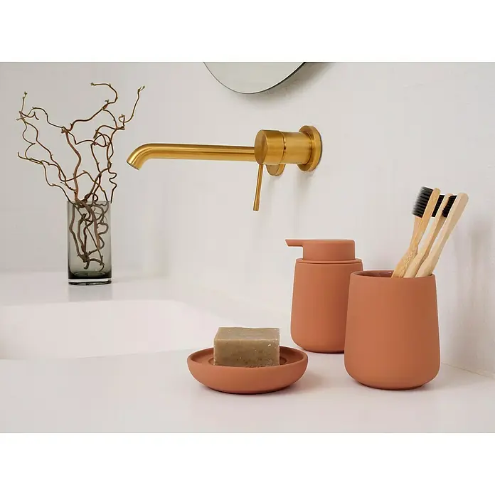 Zone Denmark Nova One Seifenspender - ABS-Kunststoff, Mandarin - Badezimmer-Set mit Seifenspender, Seifenschale und Becher für Zahnbürsten, neben einer modernen Armatur und Dekoration.