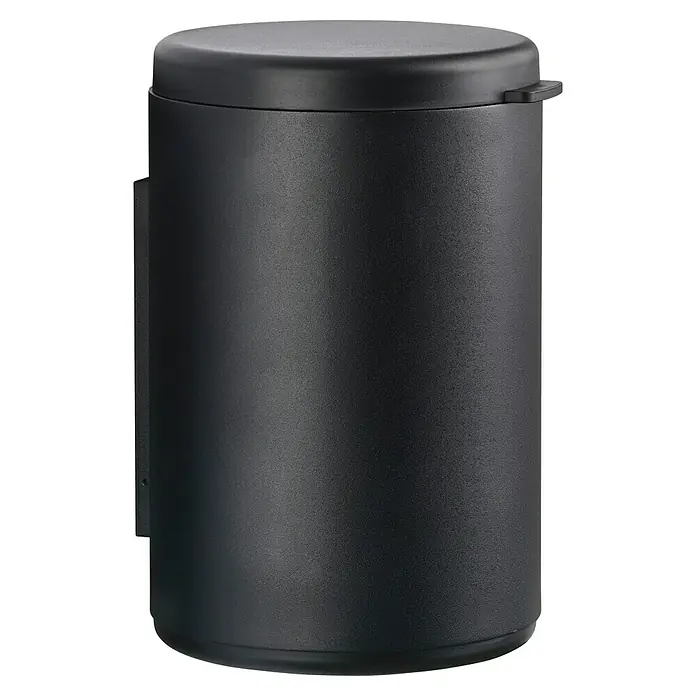 Zone Denmark Kosmetikeimer RIM - 3,3 l, Aluminium, Black - Nahaufnahme eines mattschwarzen, zylindrischen Abfallbehälters mit Deckel, der an einer Wand montiert ist und eine minimalistische Ästhetik aufweist.