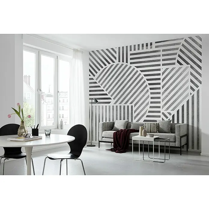Komar Flair Fototapete Jeux de Lignes - B x H: 300 x 250 cm, Vlies, Schwarz/Weiß - Wohnzimmer mit geometrischer Tapete, Esstisch mit Stühlen und Sofa mit Beistelltischen. Moderner Wohnstil mit Designelementen.