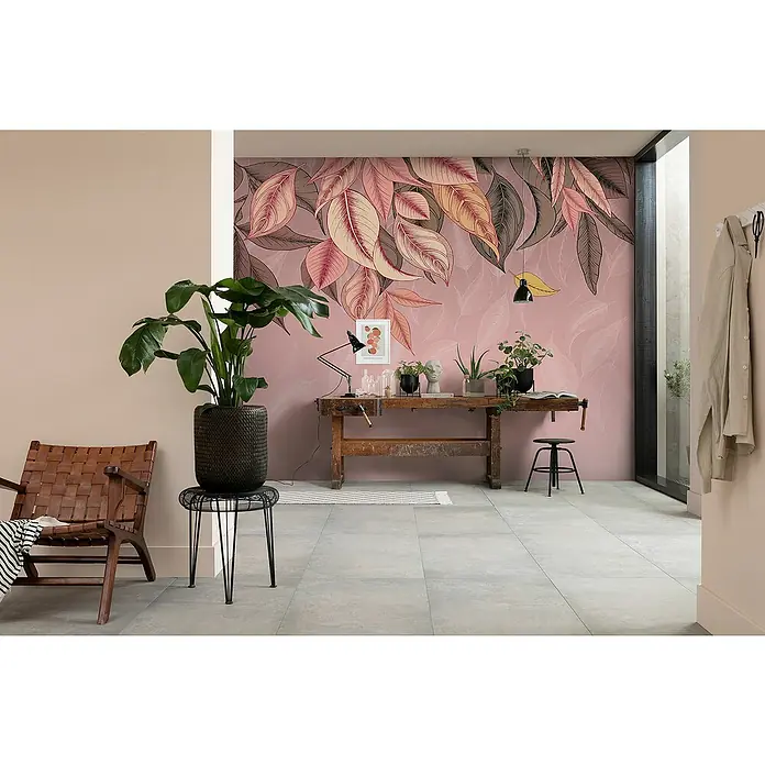 Komar Flair Fototapete Falling Leafs - B x H: 350 x 250 cm, Vlies - Ein einladender Raum mit einer stilvollen Arbeitsbank, einem üppigen Zimmerpflanze und einem auffälligen Blattmuster an der Wand.