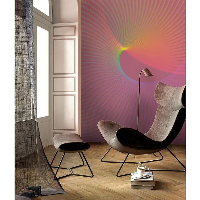 Komar Flair Fototapete Frequenz - B x H: 200 x 250 cm, Vlies - Wohnzimmer mit Design-Sessel und Fußhocker, Bücherstapel mit Tasse darauf und abstrakter Wandkunst in Rosa- und Gelbtönen.