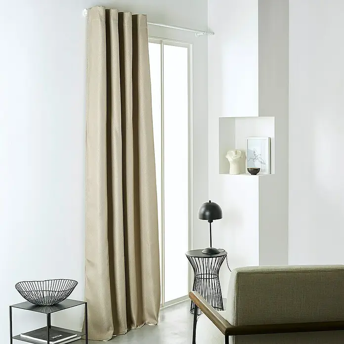 Verdunkelungsvorhang Chambray - B x H: 140 x 240 cm, 100 % Polyester, Dune - Beige Vorhänge hängen elegant vor einem Fenster und verleihen dem Raum eine warme, einladende Atmosphäre. Die Textur der Vorhänge ist gut sichtbar.