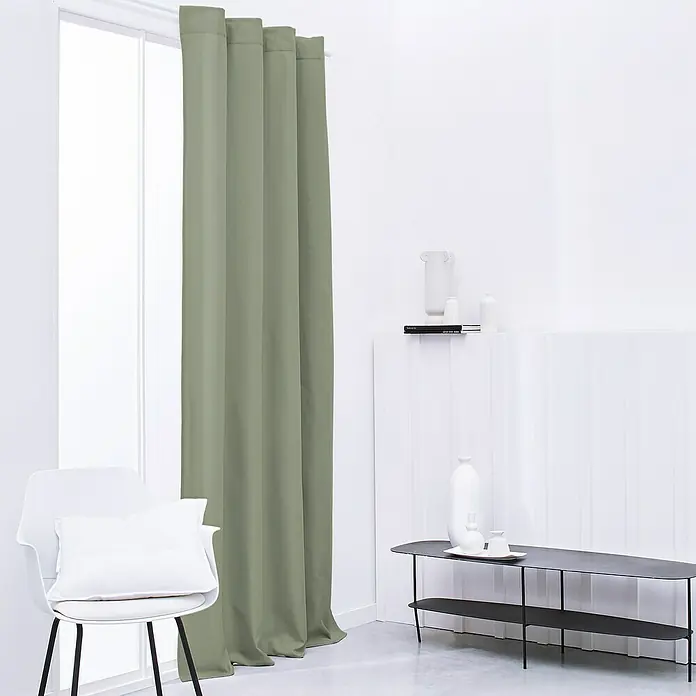Thermovorhang - B x H: 140 x 240 cm, 100 % Polyester, Salbei - Wohnzimmer-Interieur mit olivgrünen Verdunkelungsvorhängen, die das Fenster verdecken, und einem weißen Stuhl mit Kissen. Minimalistisch eingerichtet.