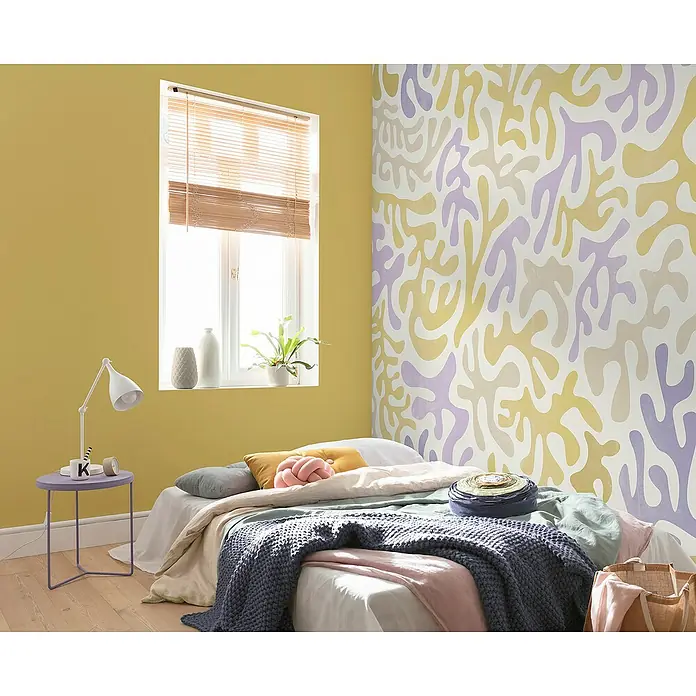 Komar Flair Fototapete Sage Flip - B x H: 350 x 250 cm, Vlies - Schlafzimmer mit gelber Wand, gemusterten Akzentwand, Bett mit Wurfkissen und Nachttisch mit Lampe.