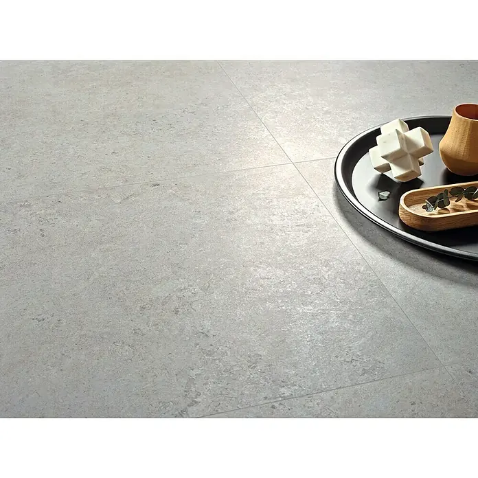 Pavimento porcelánico Limestone - 60 x 60 cm, Gris, Mate, Rectificado - Primer plano de baldosas de suelo grises modernas con elementos decorativos en una bandeja negra que muestra un interior elegante.
