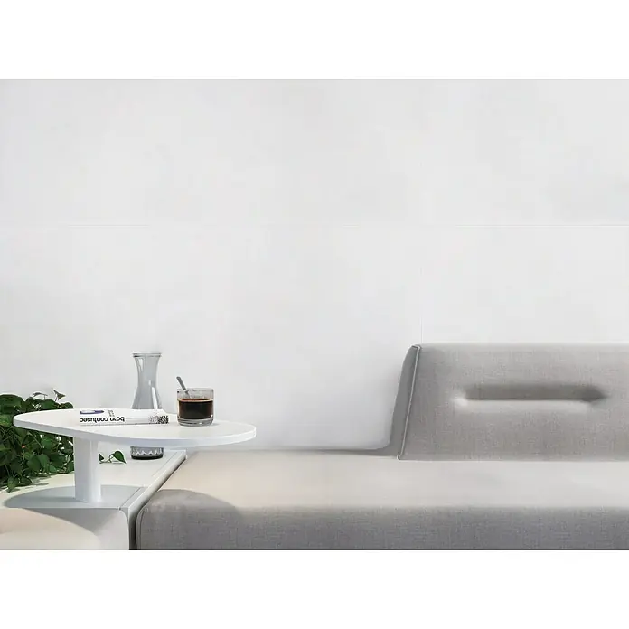 Pavimento porcelánico Fresh - 60 x 120 cm, Blanco, Mate, Rectificado - Primer plano de una elegante mesa de sofá con un libro, un vaso y una bebida, transmitiendo un ambiente elegante y relajante.