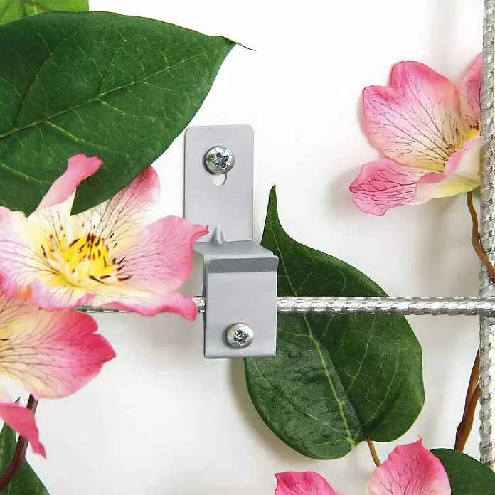 Bellissa Abstandhalter-Set für Spaliere - 4 -tlg. - Nahaufnahme eines Rankgitters mit Befestigungsclip, umgeben von grünen Blättern und rosa Blüten. Ideal für die Wandbegrünung.