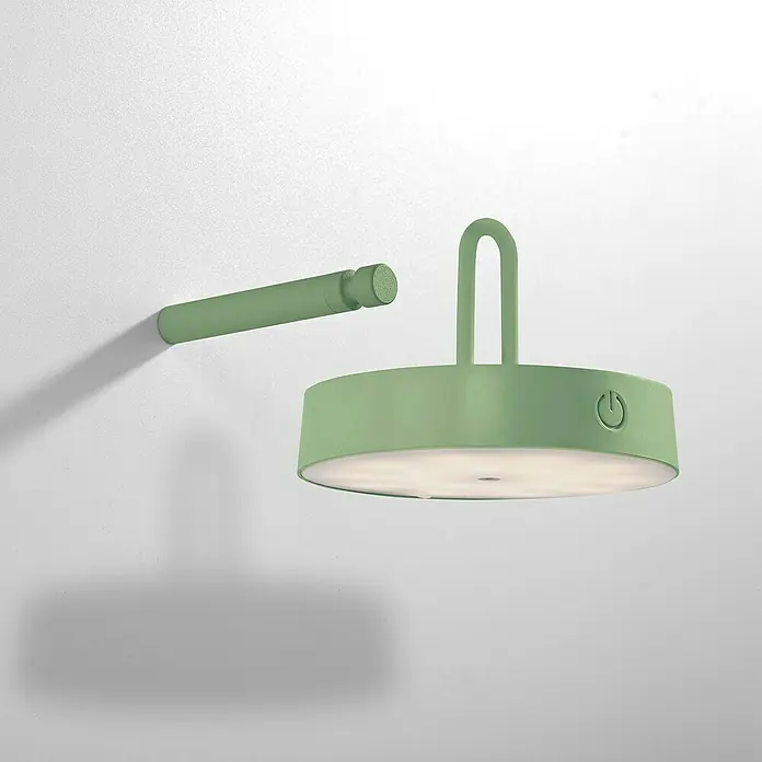 Just Light Aplique de pared con batería Arma - 12,8 x 19 x 8,7 cm, Verde, Blanco cálido, 15 W, IP44 - Primer plano de una lámpara de pared verde que emite una luz cálida y difusa, mostrando una estética moderna con un diseño funcional.
