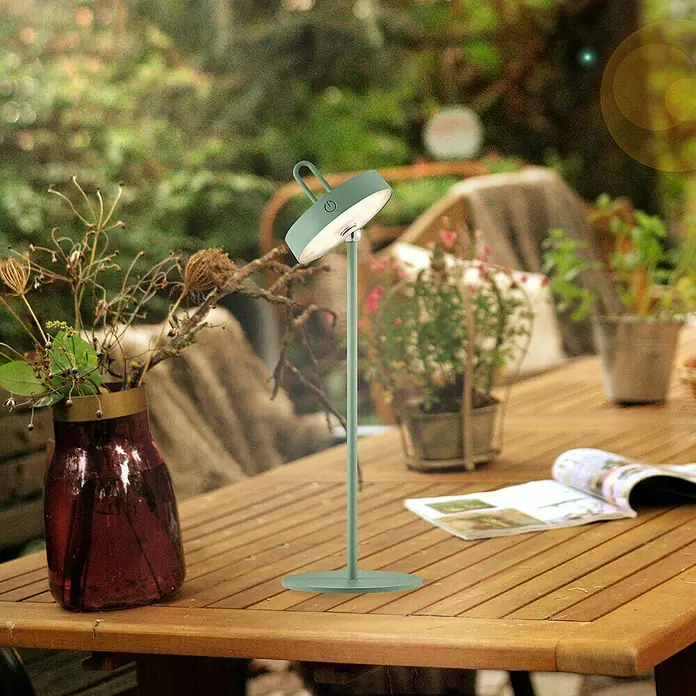 Paul Neuhaus Lámpara de sobremesa LED Amag - 1,5 W, L x An x Al: 15 x 15 x 47,2 cm, Verde, Blanco cálido - Una moderna lámpara de mesa verde sin cable está sobre una mesa de madera en el jardín, perfecta para tardes atmosféricas.