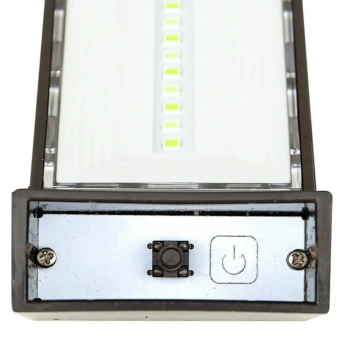 Arte confort Baliza exterior LED solar Lumeon - Blanco cálido - Primer plano de una luz LED con interruptor de encendido/apagado. La lámpara tiene un diseño elegante y es apta para uso interior.