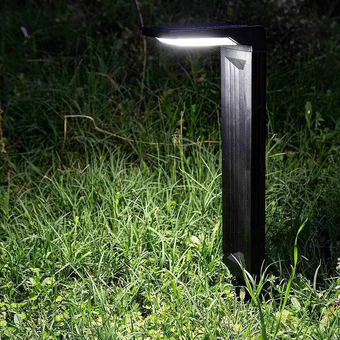 Arte confort Baliza exterior LED solar Altair - Blanco frío - Primer plano de una luz de jardín negra en un césped.