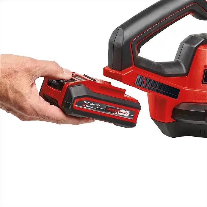 Einhell Power X-Change 18V Akku-Laubbläser GE-UB18/250LI E - 18 V, Ohne Akku, Blasgeschwindigkeit: 250 km/h, Blasleistung: 120 m³/h - Eine Hand verbindet einen rot-schwarzen Einhell Power X-Change Akku mit einem passenden Elektrowerkzeug.