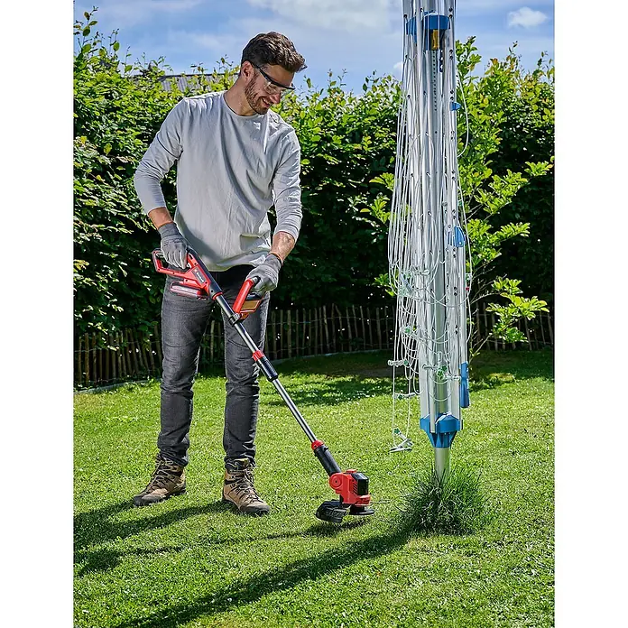 Einhell Power X-Change 18V Akku-Rasentrimmer GE-CT 18/25 Li-Solo - 18 V, Li-Ionen, Ohne Akku, Schnittbreite Messer: 25 cm - Mann verwendet einen Einhell Akku-Rasentrimmer im Garten, um Gras zu schneiden. Das Gerät ist rot und schwarz und kabellos.