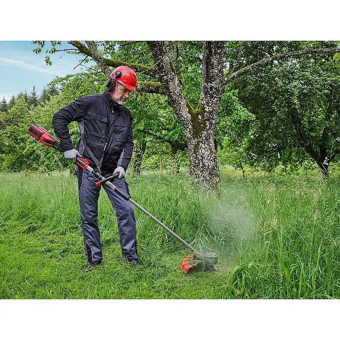 Einhell Professional Akku-Motorsense SOLO GP-BC 36/430 LI P BL - 36 V, Ohne Akku, Schnittbreite Faden: 43 cm, Schnittbreite Messer: 25,5 cm - Ein Mann benutzt einen Rasentrimmer mit Akku, um hohes Gras zu schneiden, mit Fokus auf das Gartengerät.
