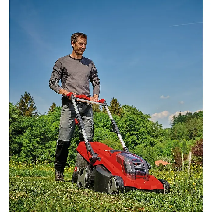 Einhell Power X-Change 18V Akku-Rasenmäher Rasarro 36/40 - 36 V, 2 Akkus, 4 Ah, Schnittbreite: 40 cm - Ein Mann benutzt einen roten Einhell Akku-Rasenmäher im Garten, um das Gras zu schneiden. Der Rasenmäher ist kabellos und einfach zu bedienen.
