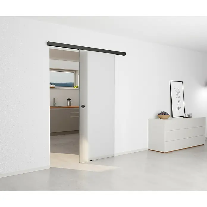Entravia Abstands-Set Bright-Slide - Schwarz eloxiert, 2.000 mm, Passend für: Entravia Bright-Slide Schiebetüren vor der Wand laufend - Moderne Raumansicht mit einer eleganten Schiebetür aus Glas, die den Blick auf eine helle Küche freigibt und stilvolles Design zeigt.