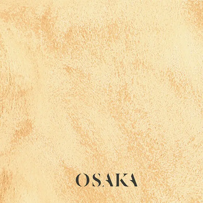 Osaka Pintura para efectos decorativos Arena - 5 l, Crema, Mate - Letrero de Osaka sobre un fondo beige con textura. Ideal para proyectos de diseño que buscan una elegancia sutil.