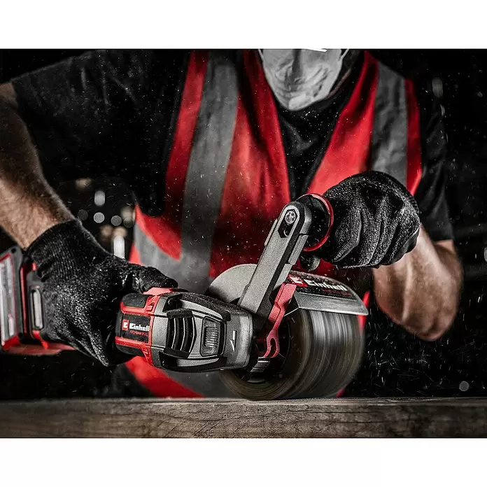 Einhell Professional Power X-Change 18V Akku-Bürstenschleifer TP-BR 18/32 Li BL - Solo - 18 V, Ohne Akku - Eine Person in Schutzkleidung verwendet einen rot-schwarzen Akku-Bandschleifer zum Glätten einer Holzoberfläche, mit sichtbaren Staubpartikeln.