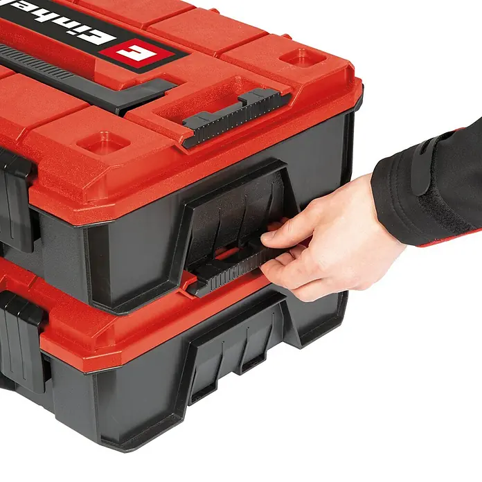 Einhell Systemkoffer E-Case S-F - L x B x H: 44,4 x 33 x 13,1 cm, Polypropylen, Traglast: 25 kg - Ein roter und schwarzer Einhell Werkzeugkoffer wird von einer Hand geöffnet, die den Verschluss betätigt.