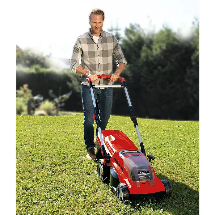 Einhell Power X-Change 18V Akku-Rasenmäher Rasarro 36/36 - 36 V, 2 Akkus, 3 Ah, Schnittbreite: 36 cm - Ein Mann benutzt einen roten Einhell Rasenmäher im Garten, um das Gras zu mähen. Das Gerät ist kompakt und leicht zu manövrieren.
