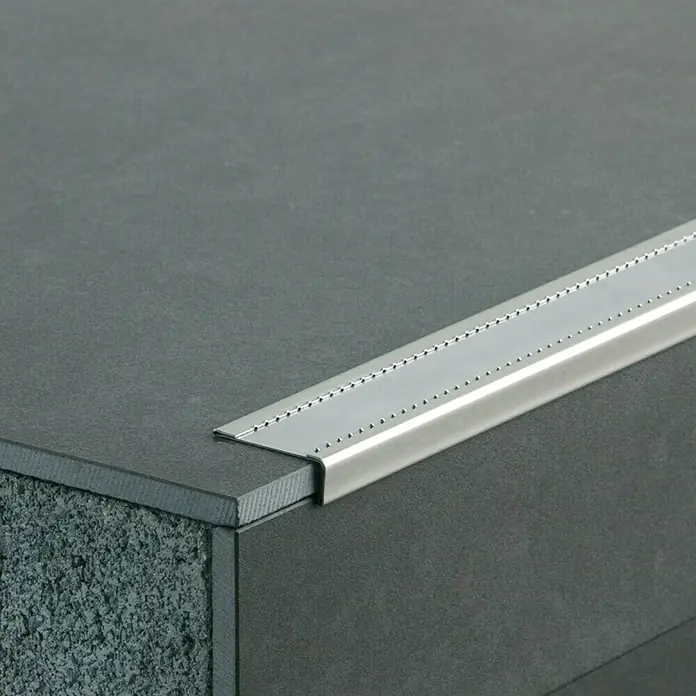 Escalón autoadhesivo - 1 m x 41 mm x 14,5 mm, Acero - Perfil de borde de escalera de aluminio sobre una escalera gris, que ofrece seguridad y un acabado elegante.