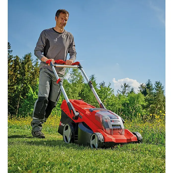 Einhell Power X-Change 18V Akku-Rasenmäher Rasarro 36/42 - 36 V, 2 Akkus, 5,2 Ah, Schnittbreite: 42 cm - Ein Mann schiebt einen roten Einhell Akku-Rasenmäher über einen grünen Rasen vor Bäumen und blauem Himmel.
