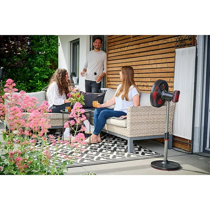 Einhell Power X-Change 18V Akku-Ventilator GE-CF 18/320 P Li-Solo - 18 V, Ohne Akku - Terrasse mit Ryobi-Akku-Ventilator: Zwei Frauen sitzen auf der Couch, ein Mann steht.