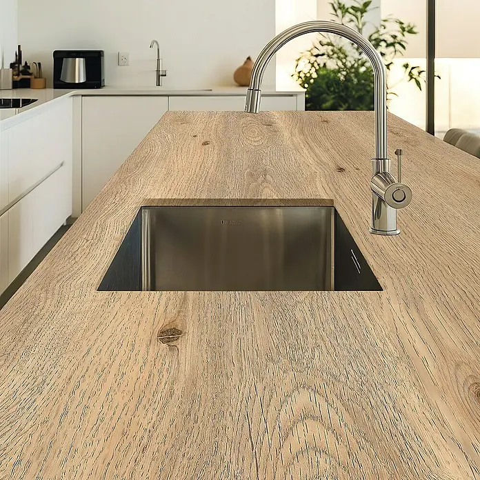 Lámina decorativa autoadhesiva vinílico para encimera - 65 x 200 cm, Oak - Primer plano de un fregadero de cocina de acero inoxidable, perfectamente integrado en una encimera de madera clara con veta distintiva y un grifo elegante.