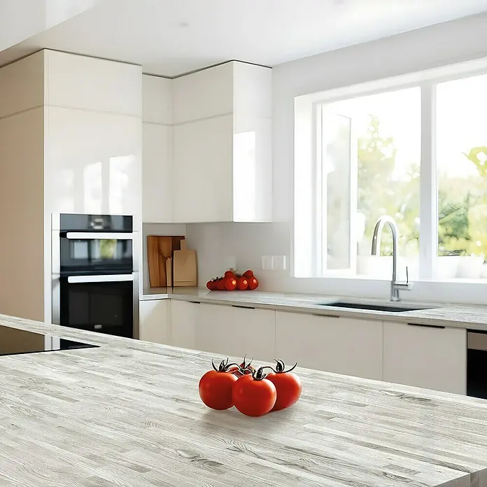 Lámina decorativa autoadhesiva vinílico para encimera - 65 x 200 cm, Malmo gris - Vista de la cocina con una encimera de madera y tomates frescos en primer plano. Los armarios de la cocina son modernos y blancos.