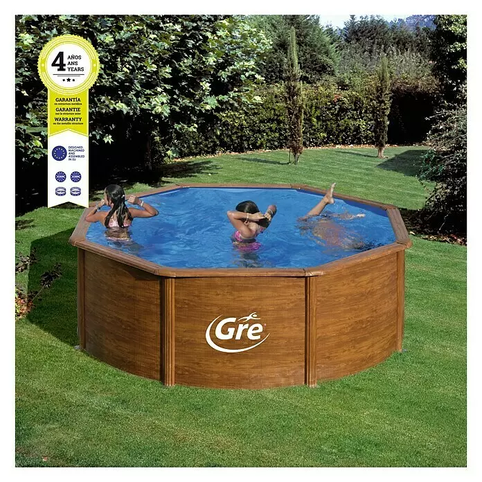 Gre Piscina de acero desmontable Sicilia - Ø x Al: 300 x 120 cm, Marrón claro, 7.418 l - Piscina elevada hexagonal con acabado de madera en un jardín. Tres personas nadan en el agua azul.