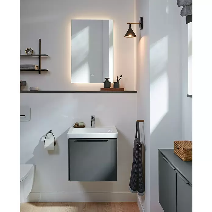 Villeroy & Boch Subway 3.0 Handwaschbecken - 50 x 40 cm, Mit schmutzabweisender Glasur, Hahnloch: Mitte, Ohne Überlauf, Weiß Alpin, Ungeschliffen, Waschbecken geeignet für: Möbel - Modernes Badezimmer mit wandmontiertem dunkelgrauem Waschtischunterschrank, weißem Waschbecken, beleuchtetem Spiegel und Toilette.