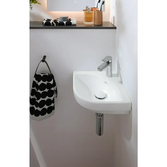 Villeroy & Boch Subway 3.0 Handwaschbecken - 45 x 37 cm, Ohne Spezialglasur, Hahnloch: Mitte, Ohne Überlauf, Weiß Alpin, Eckig - Detailaufnahme eines modernen Waschbeckens mit Armatur und Handtuch im Badezimmer. Das Design ist minimalistisch und stilvoll.