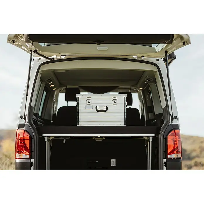 Enders Aufbewahrungs- & Transportbox Toronto 63l - L x B x H: 57 x 38 x 36 cm, Metall - Silberne Aluminium-Aufbewahrungsbox mit Griffen und Verschlüssen, platziert im geöffneten Heck eines Vans auf einer schwarzen Polsterplattform.