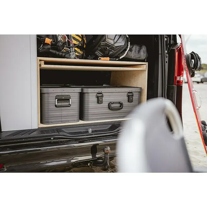 Enders Aufbewahrungs- & Transportbox Toronto S - L x B x H: 46 x 32 x 26 cm, Metall - Zwei graue, geriffelte Aufbewahrungsboxen mit dunklen Verschlüssen und Griffen, ordentlich in einem Holzregal im Laderaum eines Vans.